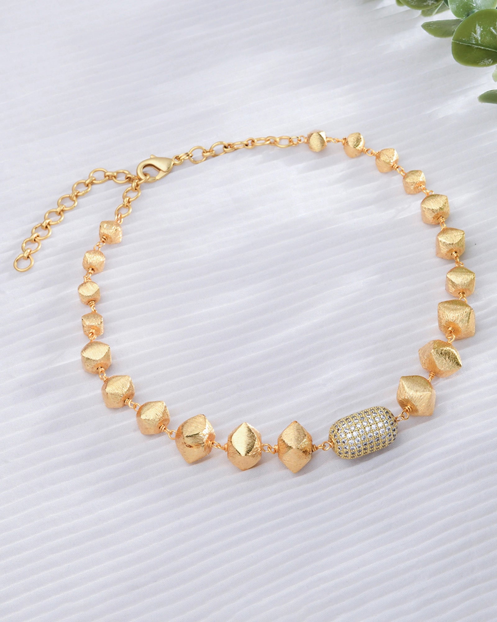 gold necklace featuring large, irregularly shaped beads