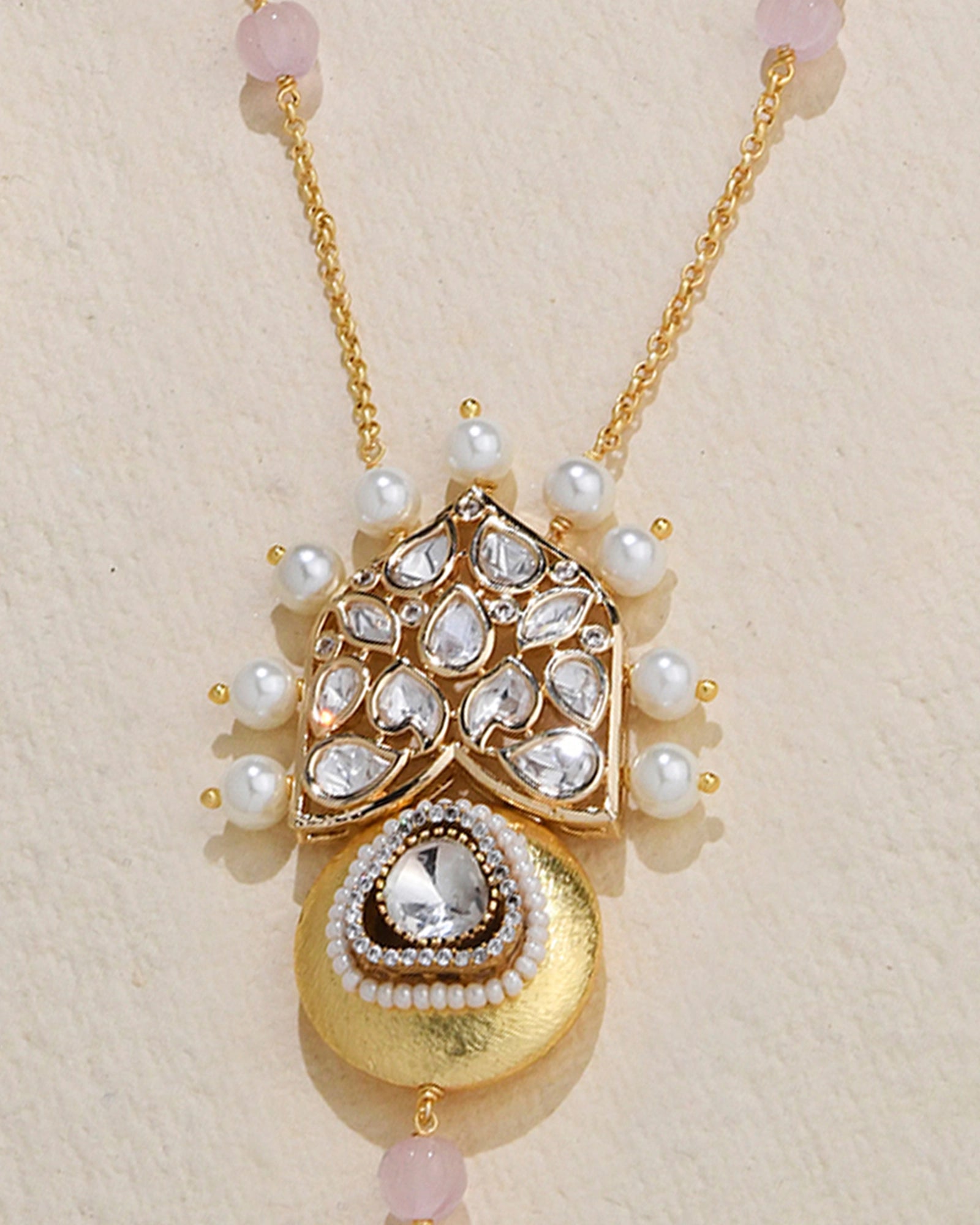 golden necklace featuring a pendant with a pearl